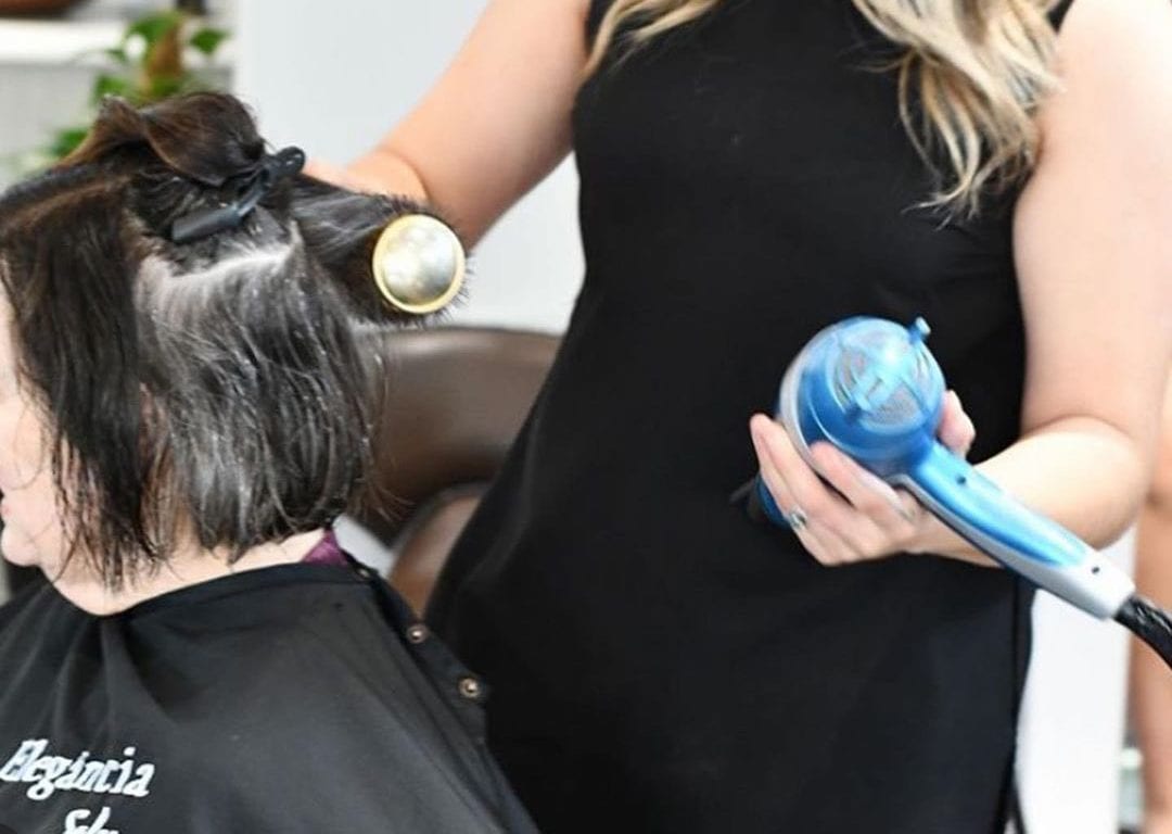 hair stylist drying client's hair with babyliss ionic dryer