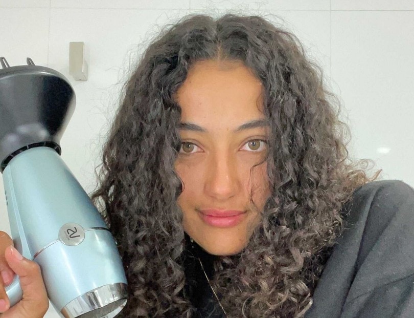 girl with natural hair holding a dryer