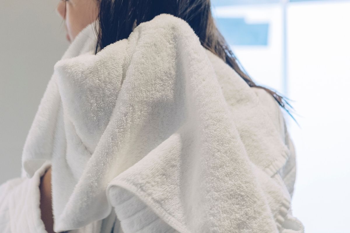 woman drying her hair with a towel