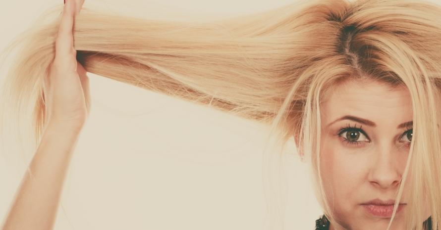 Blonde woman holding her dry hair