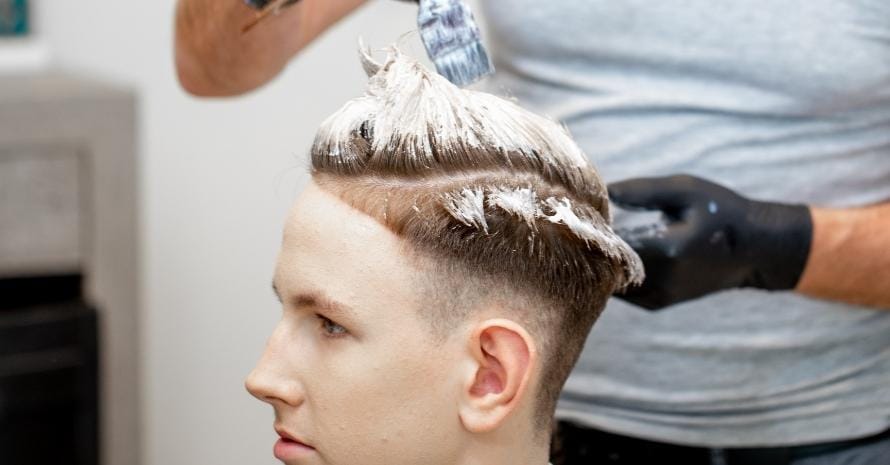 Male Hairdresser Bleaching Hair of Man