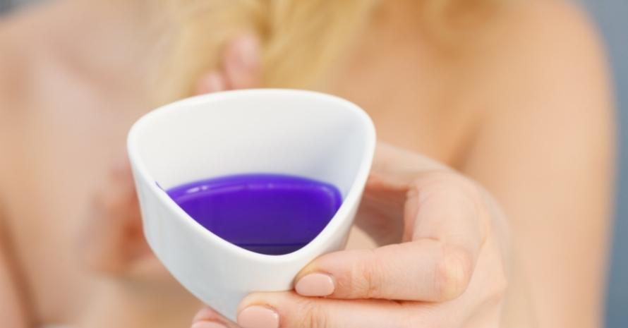 Woman pouring purple hair dye or shampoo