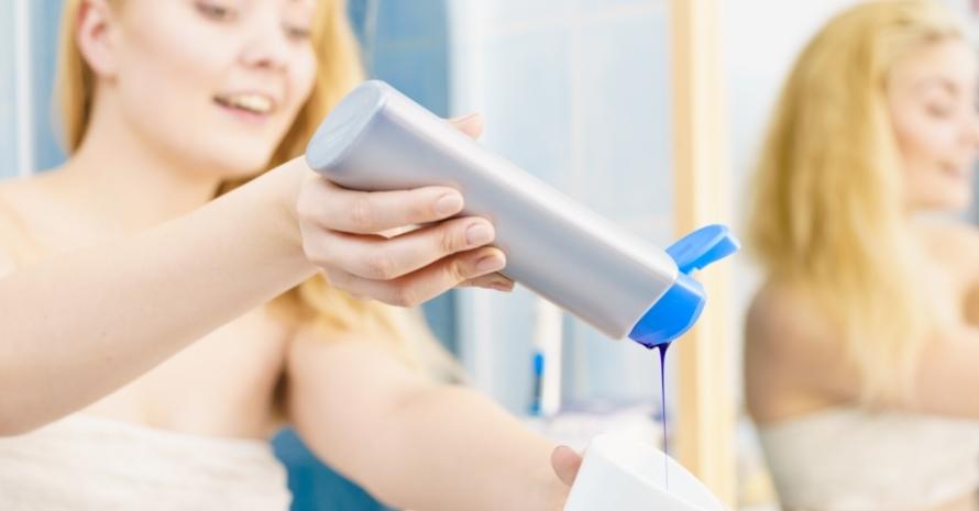 Woman pouring purple hair shampoo