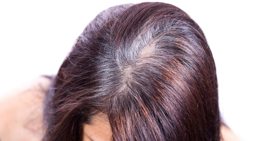 Woman shows her gray hair roots