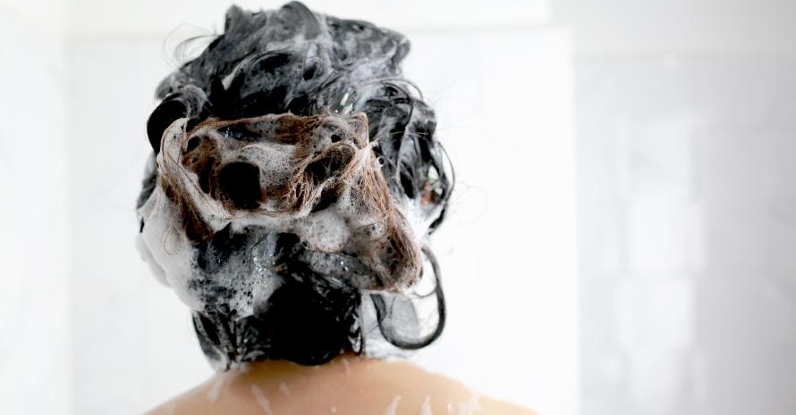 Woman washing her hair with shampoo