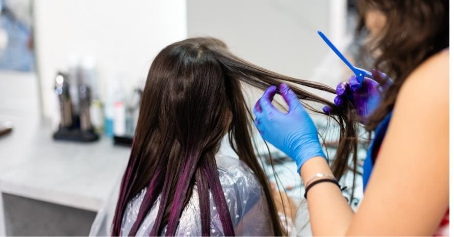 hairdresser dyes hair for a little girl