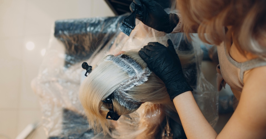 woman hairdresser dying hair at salon