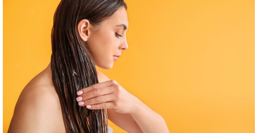 Woman applying coconut oil to her hair