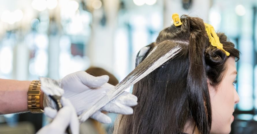Woman recives highlights in trendy hair salon