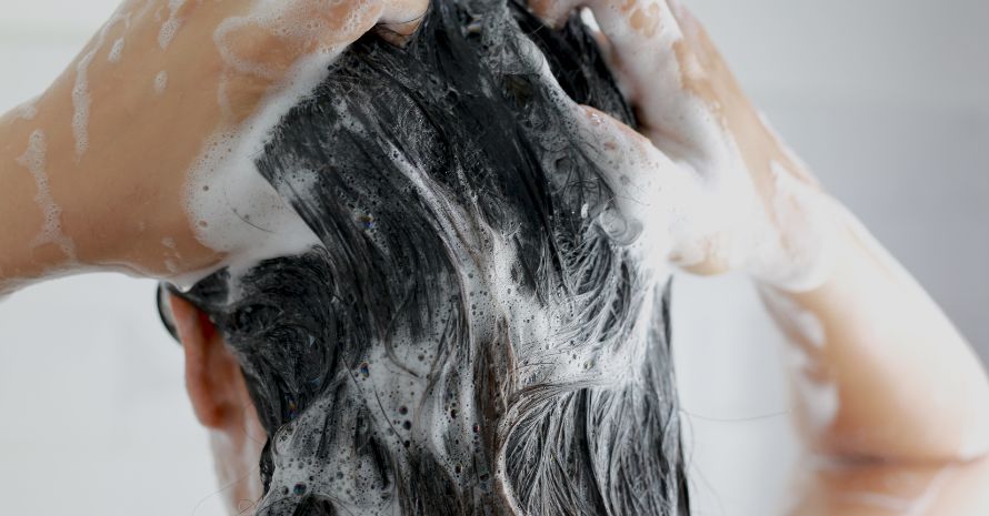 Woman washing her hair with shampoo